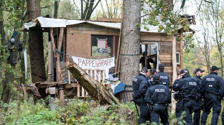Polizisten sichern im Stadtteil Altenwerder in den Vollhörner Weiden ein besetztes Baumhaus.