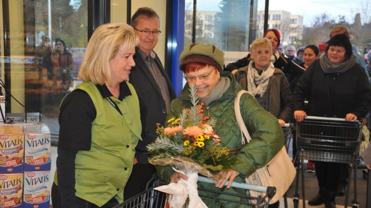 Ein Blumenstrauß für die erste Kundin: Marktleiterin Marion Wordelmann begrüßt Anita Düde aus Techentin.