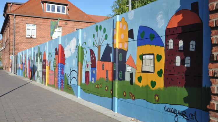 Kunterbunt und farbenfroh: Passend zum Kita-Namen „Villa Kunterbunt“ ziert die Betonwand nun bunte Häuser in der Willi-Fründt-Straße. 