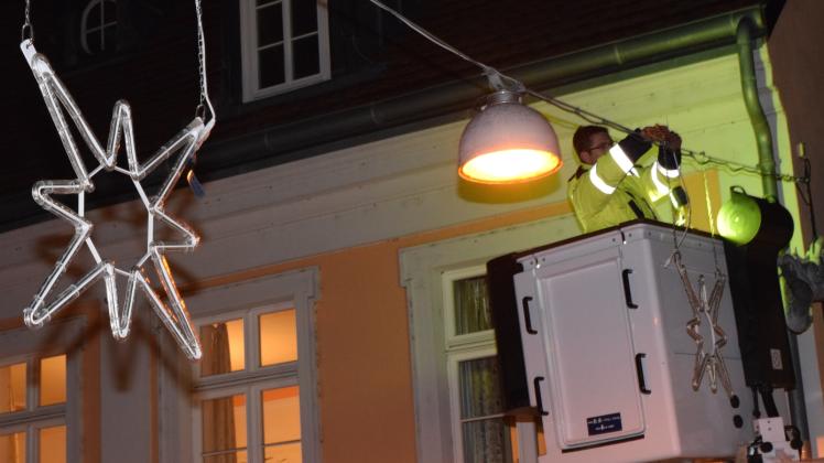  Stadtwerke-Mitarbeiter Christian Kammler montiert einen Leucht-Stern in der Güstrower Domstraße. 