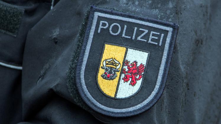  Das Dienstwappen der Polizei Mecklenburg-Vorpommern an der Uniform einer Polizistin. In Schwerin beginnt am 20.11.2019 der Prozess gegen einen Polizisten und mutmaßlichen Prepper wegen illegalen Waffenbesitzes. 