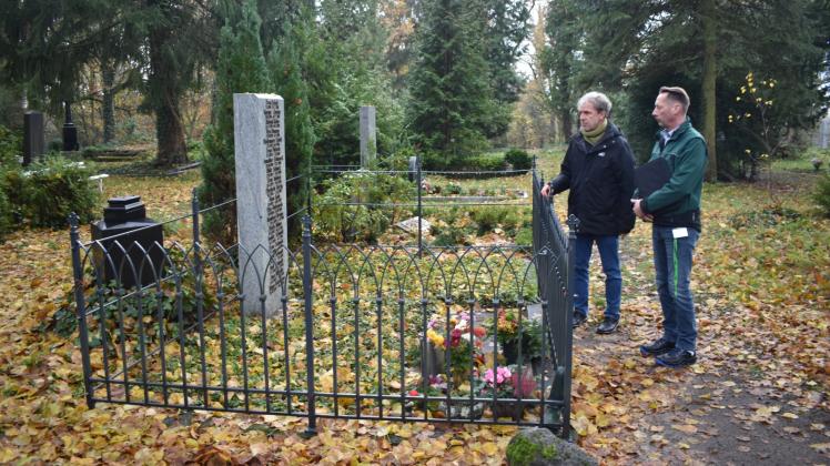 Denkmalschutz im Blick:  Nonno Schacht und René Lenzian (r.) begutachten die aufgearbeitete gusseiserne Grabeinfassung. 