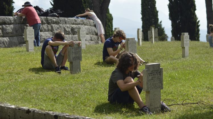 Jugendliche mehrerer Nationen arbeiten auf dem deutschen Friedhof.