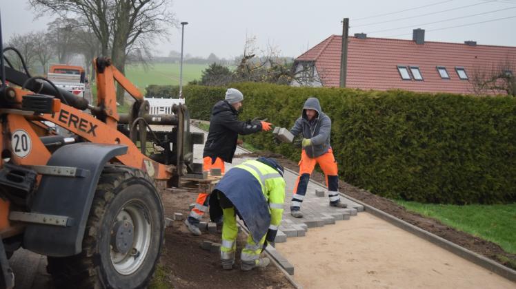 Arbeiter bei der Neuverlegung des Gehweges