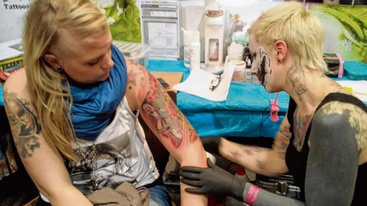 Birte aus Münster (l.) lässt sich von  Mia Reloaded Tries ein neues Tattoo stechen. Foto: Zimmermann