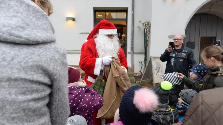 Erst schaute der Weihnachtsmann nur aus dem Fenster, dann kam er die Treppen hinunter und öffnete vor dem Langen Haus in Rehna den Geschenkesack.  Fotos: Schmidt 