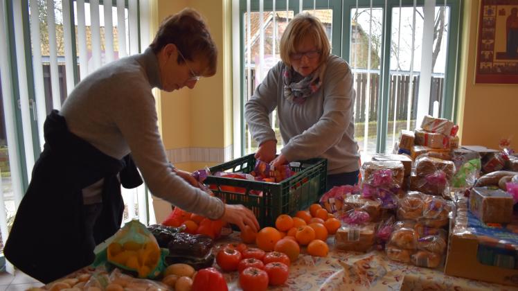 Die Mandarinen werden aus den Netzen geholt, bevor Margret Grieß (l.) und Renate Suhrau sie an die Bedürftigen der Dömitzer Tafel im katholischen Pfarramt verteilen.