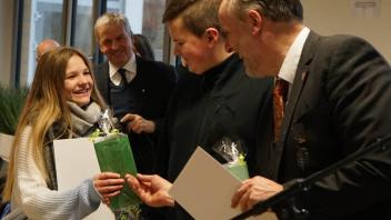 Bürgermeister Heiko Gerstmann (r.) ehrt das Engagement von Luise und Florian Scholl für den Kinder- und Jugendbeirat.