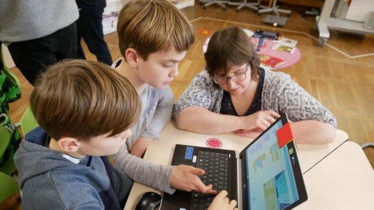 Lehrerin Medlinda Deutges hilft Tim-Luca Günther und Giulien Storbeck beim Programmieren ihres Spiels. 