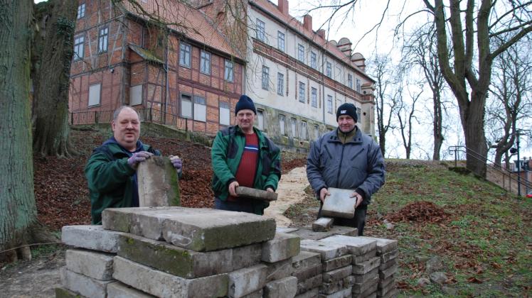 Sie haben Steine entfernt und den Weg vor dem Schloss planiert: Bernd Lübbert, Dieter Holst, Marcel Behnke (v. l.) und weitere Kollegen vom Tafelgarten Schwerin.