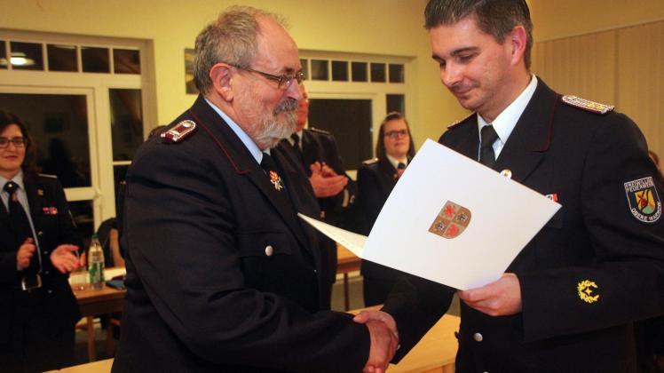 Wehrführer David Wollgandt (r.) überreicht Dieter Stieler das silberne Brandschutz-Ehrenzeichen für 25 Jahre Mitgliedschaft.
