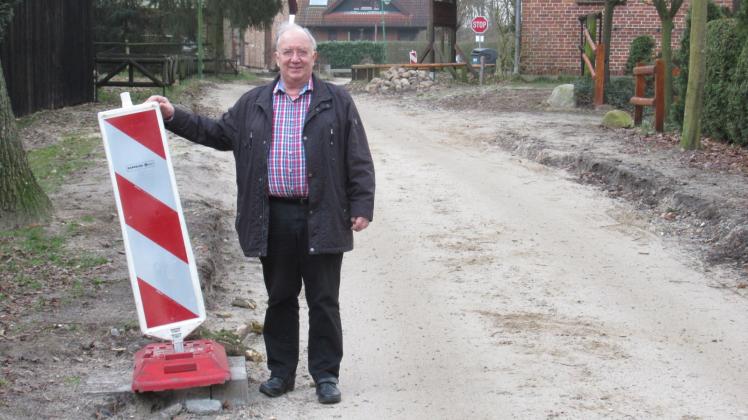 Die Baustelle ist bald Geschichte: Bürgermeister Harald Elgeti an einer der Markierungen an der Straße „Am Teich“. Wenn alles läuft, braucht es auch diese Absperrung unweit des Gewässers bald nicht mehr. 