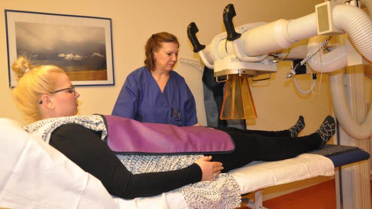 Strahlen gegen Schmerzen im Knie: Helios-Mitarbeiterin Angelika Karck richtet die Röntgentherapieanlage aus.