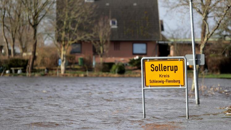 Das Ortsschild von Sollerup steht im Wasser. In der Gegend um Eggebek fielen im bisherigen Februar drei  Mal so hohe Niederschlagsmengen wie normal.