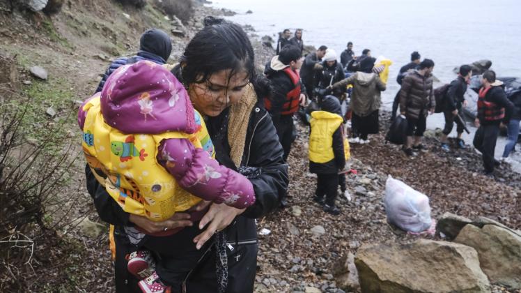 Eine Migrantin hält ein Baby an der Küste der griechischen Insel Lesbos auf dem Arm: Itzehoes SPD möchte, dass die Stadt mehr Menschen aus dem türkisch-griechischen Grenzland aufnimmt. 