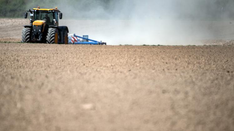 Trockenheit seit mehreren Wochen: Ein Landwirt, der mit seinem Traktor das Feld bearbeitet, zieht eine Staubwolke hinter sich her.