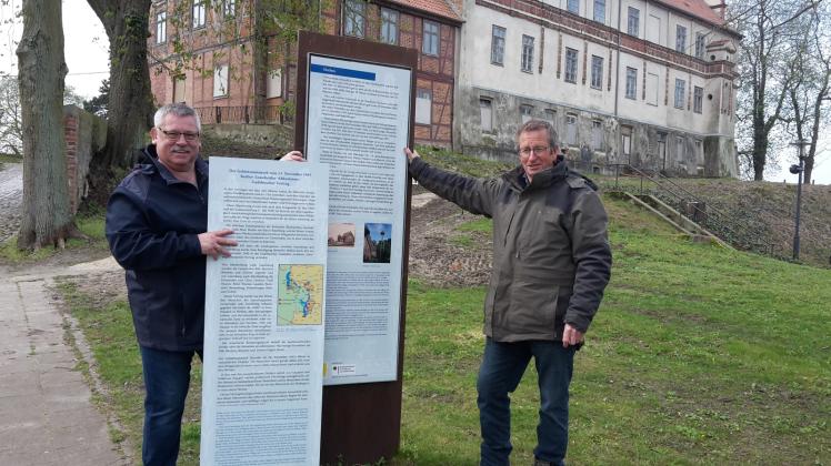 Sie präsentieren die Info-Tafeln: Klaus Leuchtemann (l.), Beauftragter für das Projekt „75 Jahre Gadebuscher Vertrag“, und Uwe Tews, Leiter des Gadebuscher Bauhofes, vor dem Schloss in der Münzstadt.