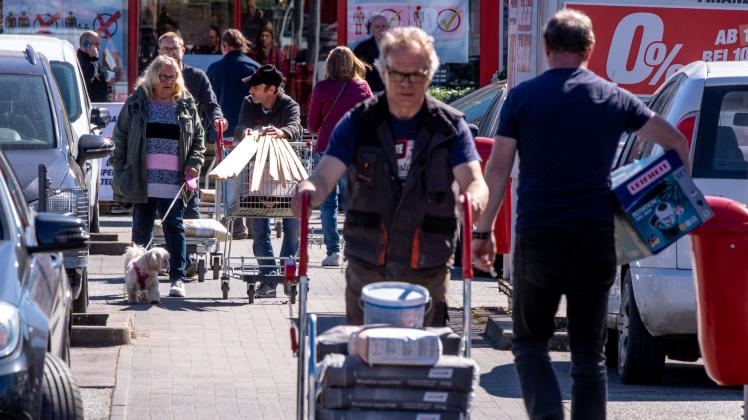 Kunden verlassen mit vollen Einkaufswagen einen wieder eröffneten Bau- und Gartenmarkt in Schwerin. Kunden verlassen mit vollen Einkaufswagen einen wieder eröffneten Bau- und Gartenmarkt in Schwerin.