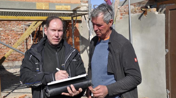 Bauleiter Ingo Kühl (links) und Dachdecker Rico Draber besprechen das weitere Vorgehen. 
