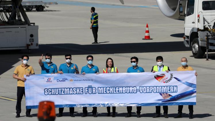 Masken geliefert: Mit einem Transparent grüßten die vietnamesische Airbus-Besatzung und die Importeurin (Mitte) vom Rollfeld des Flughafen.