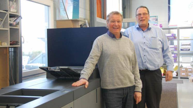 Investition in die Zukunft: Wolfgang Harm (li.) und Michael Marquardt an der neuen Digitaldruck-Maschine. In den Räumen in der Heinrich-Hertz-Straße 24 wurde einiges umgebaut, um beide Firmen unter einem Dach unterbringen zu können.