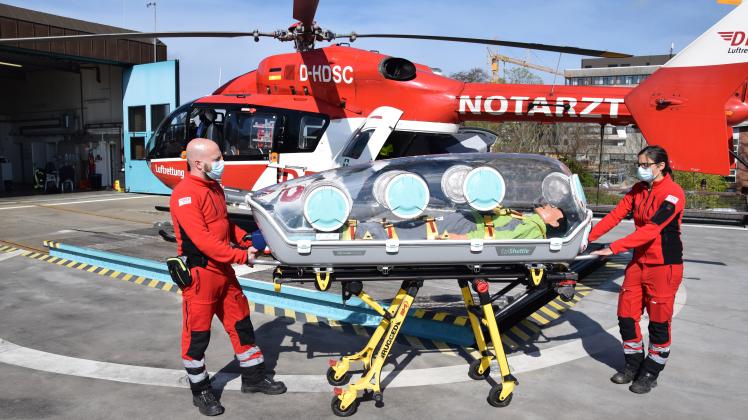 Der Notfallsanitäter Bodo Voges und die Notärztin Dr. Britta Raitschew schieben das „EpiShuttle“ zum Rettungshubschrauber „Christoph 42“, der an der DRF-Station neben der Imland-Klinik steht.