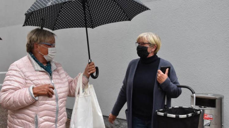 „Ihre Maske passt gut zu meinem Regenschirm“: Gitte Kleinschmidt und Ilona Haarmann (re.) lernten sich beim Gespräch über den Mund-Nasen-Schutz kennen. Fotos: Smit    