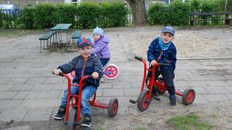 Nevio, Melina und Anton (v. l.) nutzen den Platz auf dem Kitagelände in Karstädt, um mit Dreirad und Fahrrad rumzukurven. 