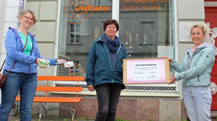 Freuen sich über den Spendenscheck des Güstrower Weltladens: Karin Fuchs (M.) und Dorina Mania (r.). Christine Schmecht zeigt unterdessen die selbst hergestellten Geldbeutel. 