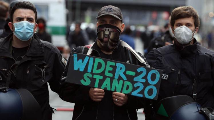 Ein „Widerstand 2020“-Demonstrant wird in Berlin von Polizisten abgeführt.