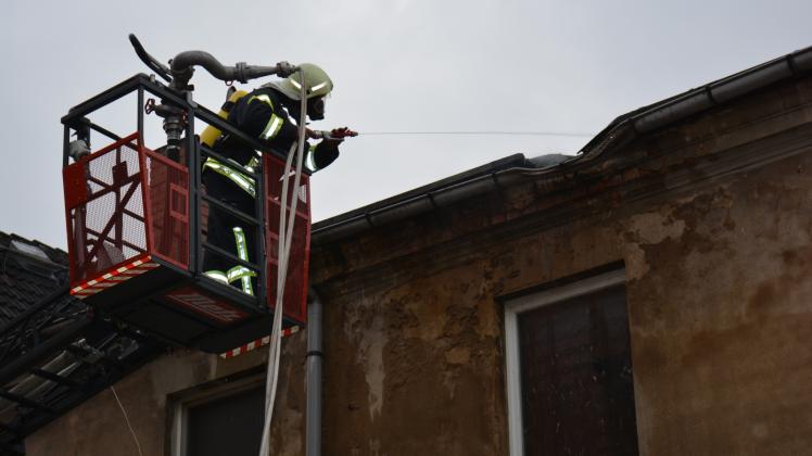 Ein Feuerwehrmann bekämpft den Brandherd unter dem Dach. 