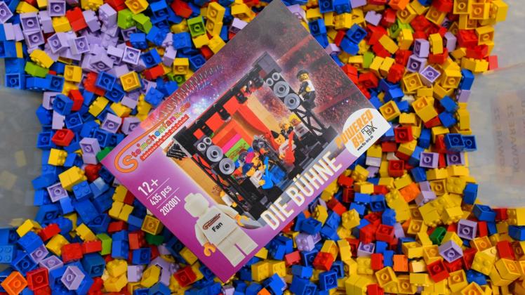 Ein von der Firma Flix Brix entworfenes Baustein-Set liegt in einer Kiste voller Lego-Steine. 