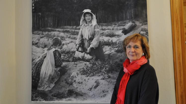 Museumsleiterin Irena Berjas neben einem großformatiger Abzug einer Marie Goslich-Fotografie