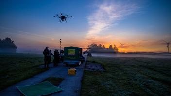 Eine Drohne mit Wärmebildkamera startet vor Sonnenaufgang neben einer Wiese in Dummerstorf. Mit dem Fluggerät suchen Tierretter im Gras liegende kleine Rehkitze.