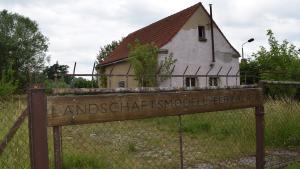 Das Holzschild weist noch auf die alte Nutzung des Geländes. 