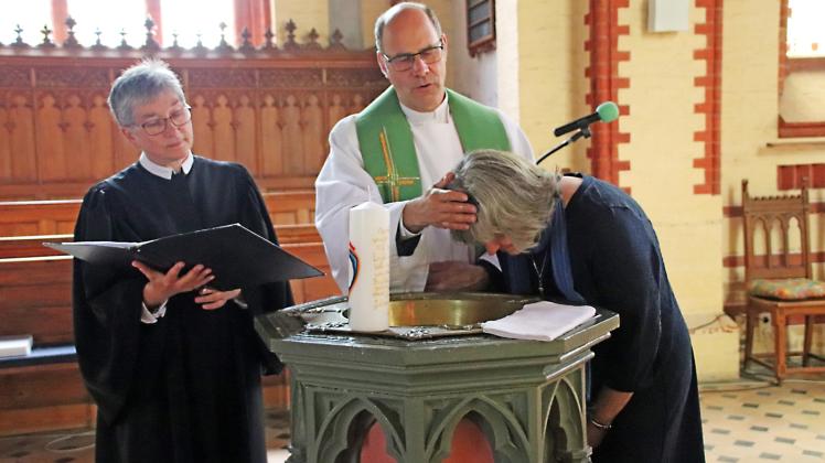 Pastor Andreas Kunert, mit Unterstützung durch Pastorin Dorothea Kunert, vollzieht die Taufzeremonie bei Ines Untrieser. 
