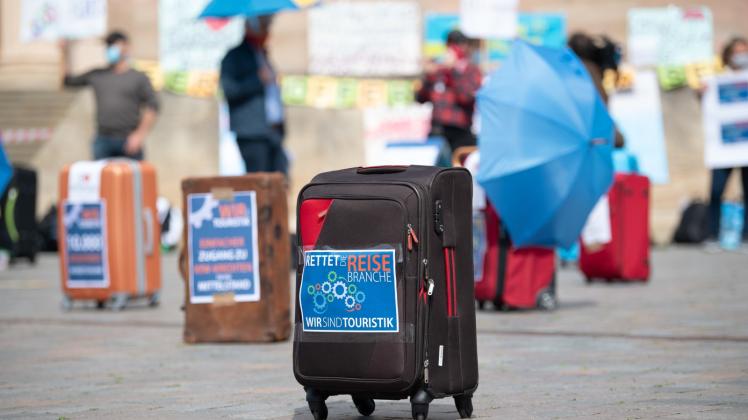 Ein Koffer mit der Aufschrift „Rettet die Reisebranche“ steht bei einem Protest auf dem Alten Markt in Potsdam. 