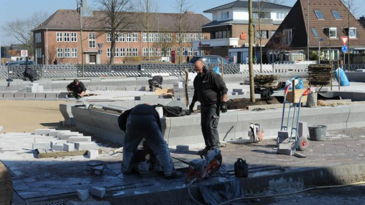 Arbeiter schneiden am Helmut-Loose-Platz Granitplatten zu und verlegen sie. Das Material stammt aus einem chinesischen Steinbruch, in dem es keine Kinderarbeit geben soll.