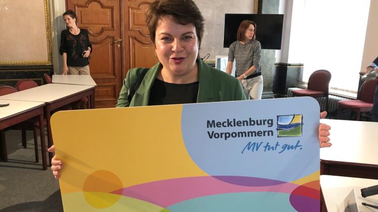 Sozialministerin Stefanie Drese (SPD) hält eine überdimensionale Kopie der Ehrenamtskarte in den Händen. 