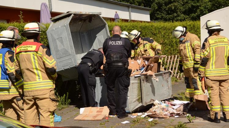 Die Feuerwehrleute öffnete den Container für die Polizisten.