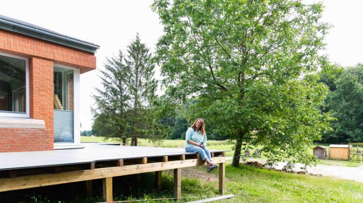 Viele helfende Hände haben das ehrgeizige Generationenprojekt „Lebendige Dorfwiese“ rund um das Bokhorster Gemeindehaus Wirklichkeit werden lassen. Initiatorin Steffi Willuweit sitzt auf der noch nicht ganz fertigen Terrasse.  