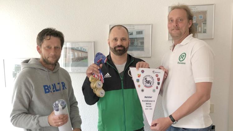 Spielausschussobmann Michael Reich (links) gratuliert Liga-Obmann Sascha Hoppe (Mitte) und Trainer Thorsten Themann vom Rendsburger TSV zum Staffelsieg in der Kreisklasse A Mitte.