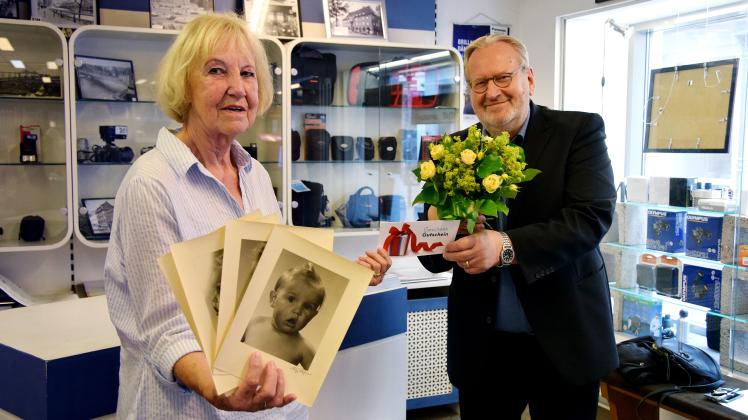 Zeigt ihre 75 Jahre alten Passbilder von Heinz Wagner: Ute Lottermoser mit dem heutigen Geschäftsinhaber Dietrich Maaß.
