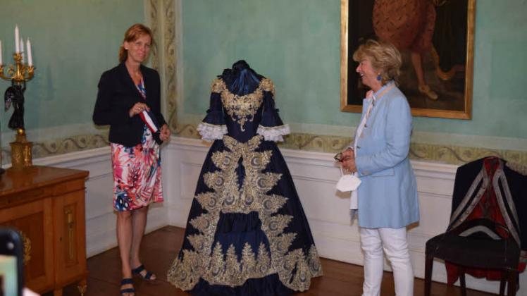 Neben bedeutenden Persönlichkeiten umfasste die Führung für Ministerin Karin Prien (links) durch Caroline Herzogin von Oldenburg auch Zeit für ein paar Details in der Ausstellung wie ein Kleid aus dem späten 18. Jahrhundert.