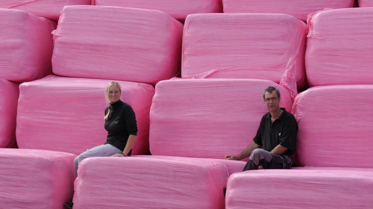 Mit pinken Siloballen machen sie auf die Brustkrebs-Vorsorge aufmerksam: Mitarbeiterin Julia Vieweg und Hans-Christian Thordsen.