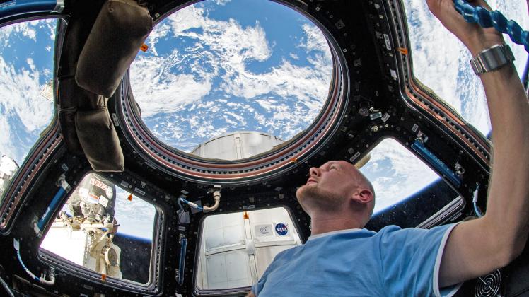 Er weiß, wie sich Schwerelosigkeit anfühlt: ESA-Astronaut Alexander Gerst vor Jahren auf der Internationalen Raumstation ISS. Durch ein Fenster in der Kuppel blickt er auf die Erde.