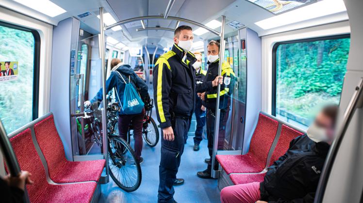 Mitarbeiter der Hamburger Hochbahn-Wache kontrollieren die Einhaltung der Maskenpflicht in einer U-Bahn.