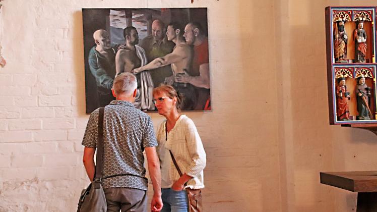 Die Gemälde von Stefan Thiel regen zum Gedankenaustausch an. Im Hintergrund das Bild „Der Heilige Thomas“