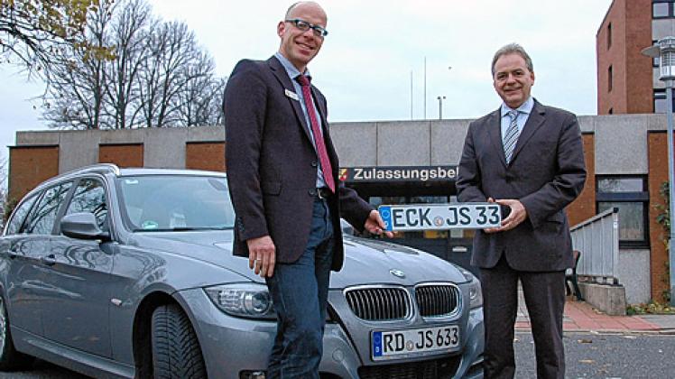 Eckernfördes Bürgermeister Jörg Sibbel (r.) nimmt von Landat Rolf-Oliver Schwemer das neue Kennzeichen (ECK-JS-33) entgegen. Foto: Laabs