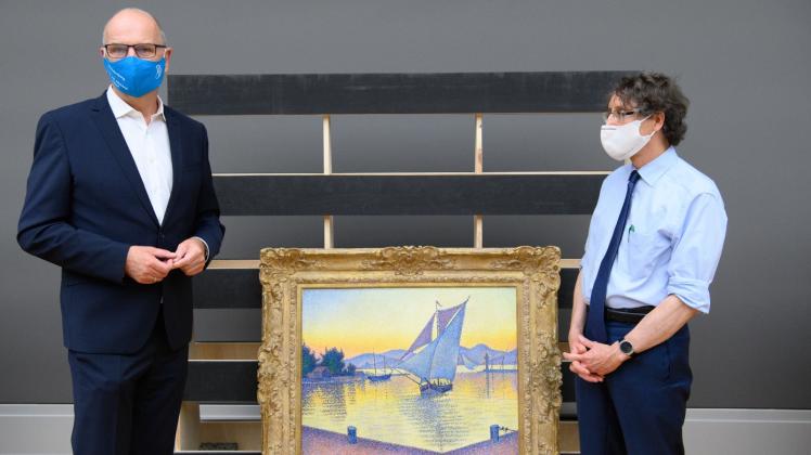 Dietmar Woidke (l.) steht im Museum Barberini neben Chefkurator Michael Philipp. Zwischen ihnen steht das Gemälde „Der Hafen bei Sonnenuntergang, Opus 236 (Saint-Tropez 1892)“ von Paul Signac.